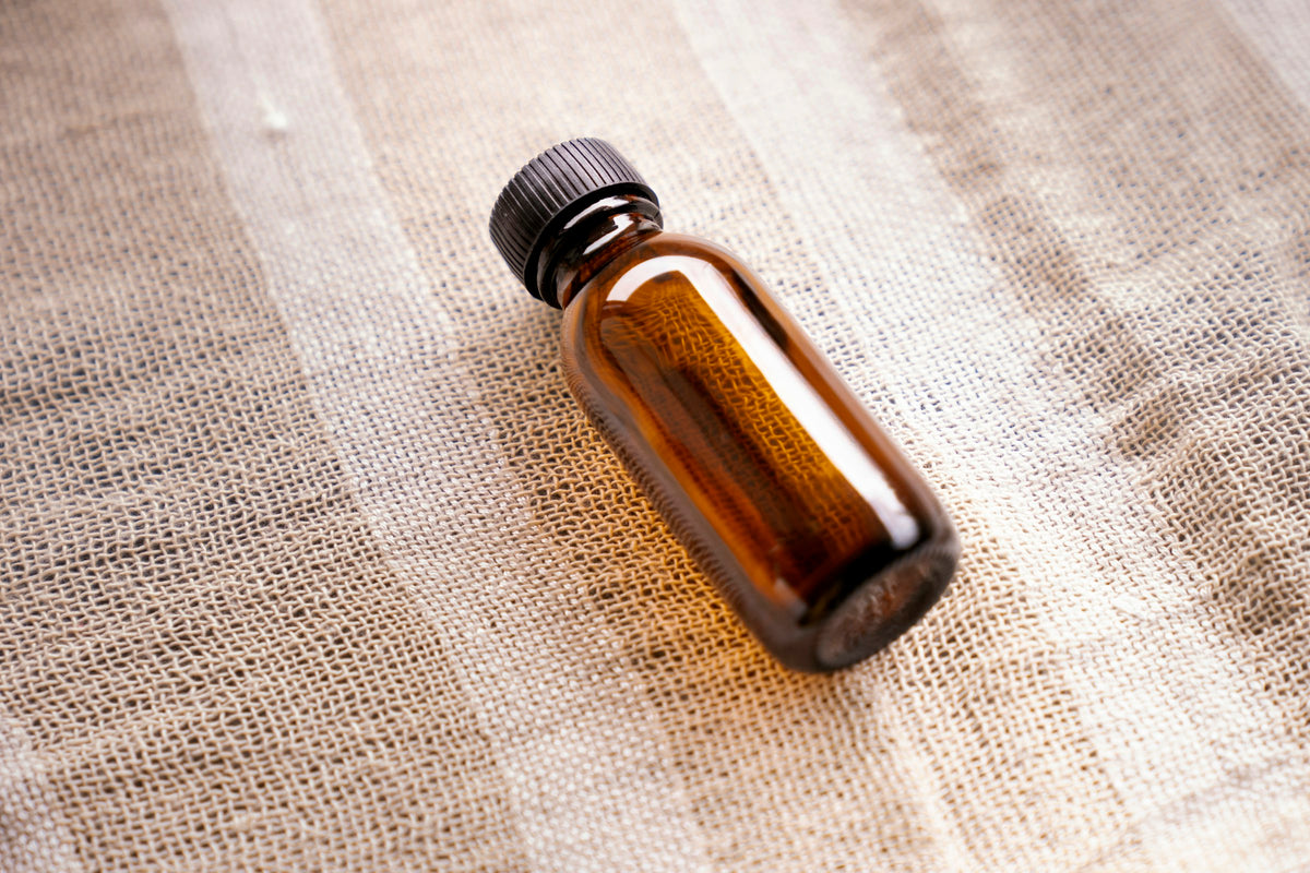 A brown glass bottle of oil on a table